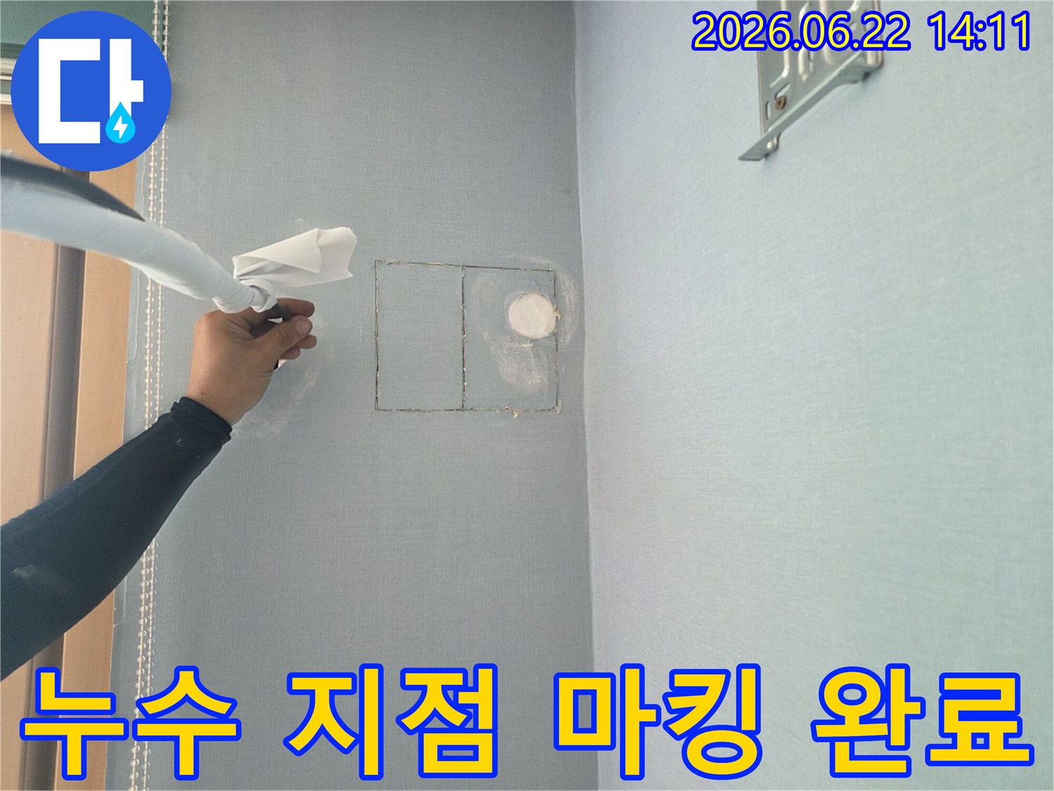 누수 탐지 전문가가-정확한 수리를 위해-벽면에 누수 지점을 표시하고 있습니다.