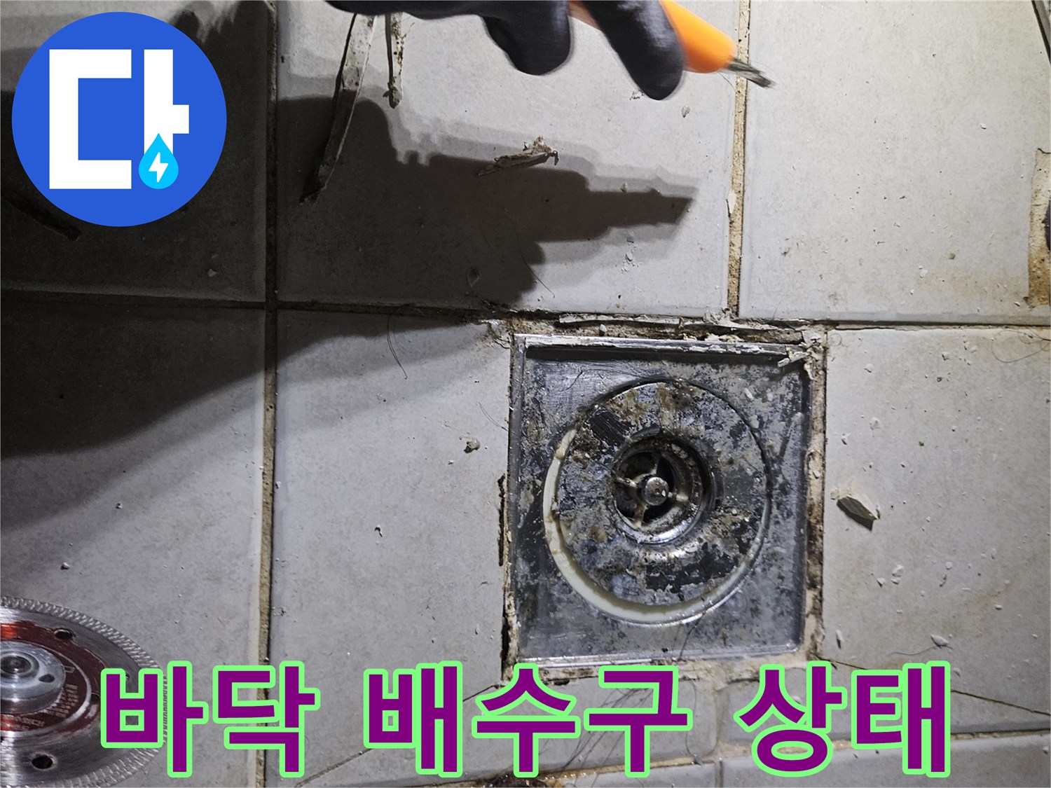 변기 탈거 후 드러난 하수구 주변의 타일 균열과 오염