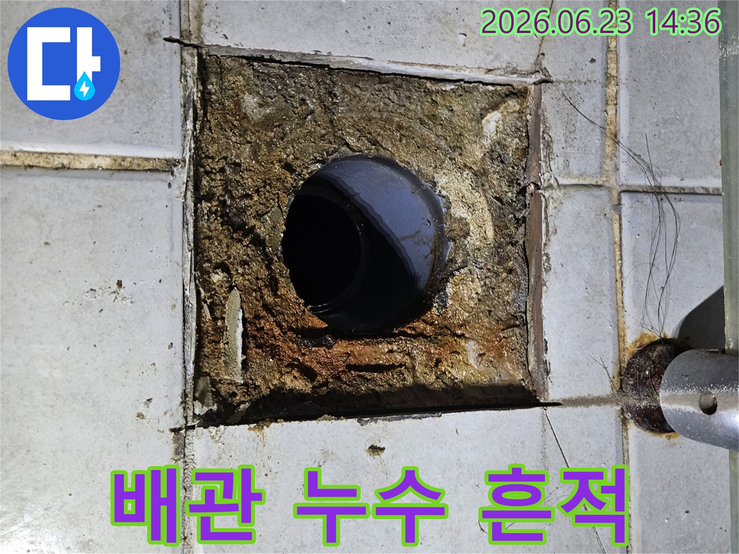 오래된 배관 주변의 누수 흔적과-손상된 타일-그리고 부식된 배수구를 보여주는 이미지