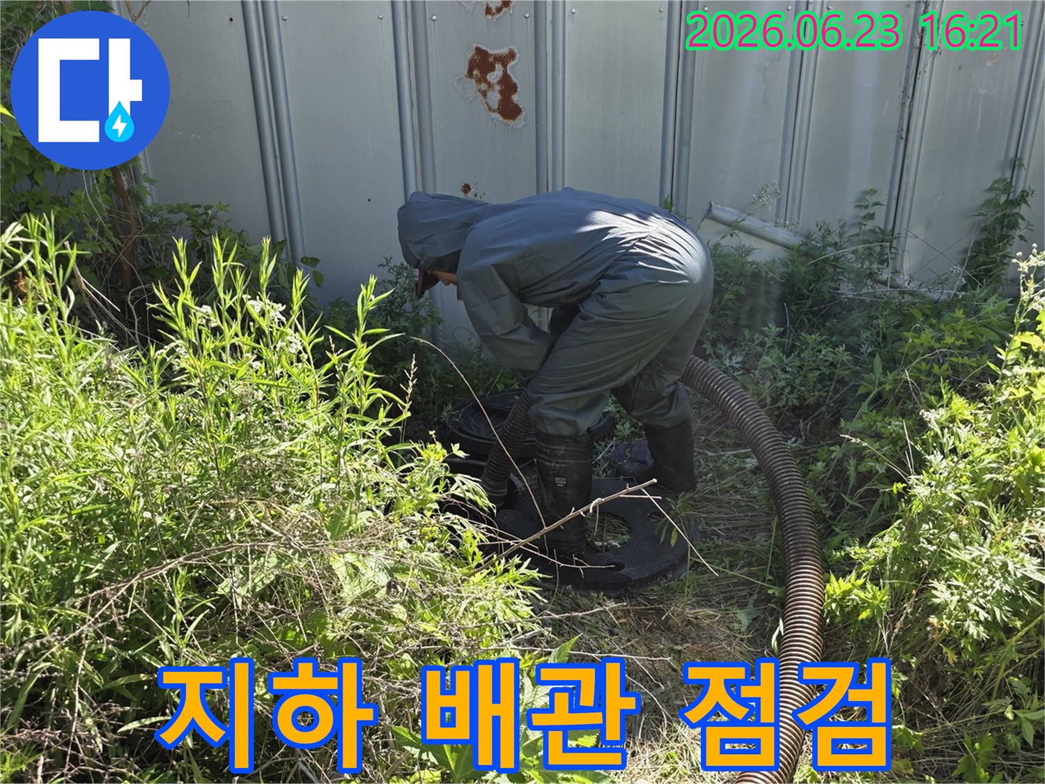 전문가가 보호 장비를 착용하고 지하 배관 점검을 위해 흡입 작업을 수행하는 현장