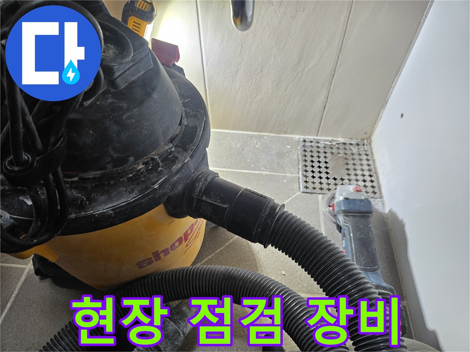 화장실 현장에서 사용 중인 강력 흡입 청소기 및 전동 공구