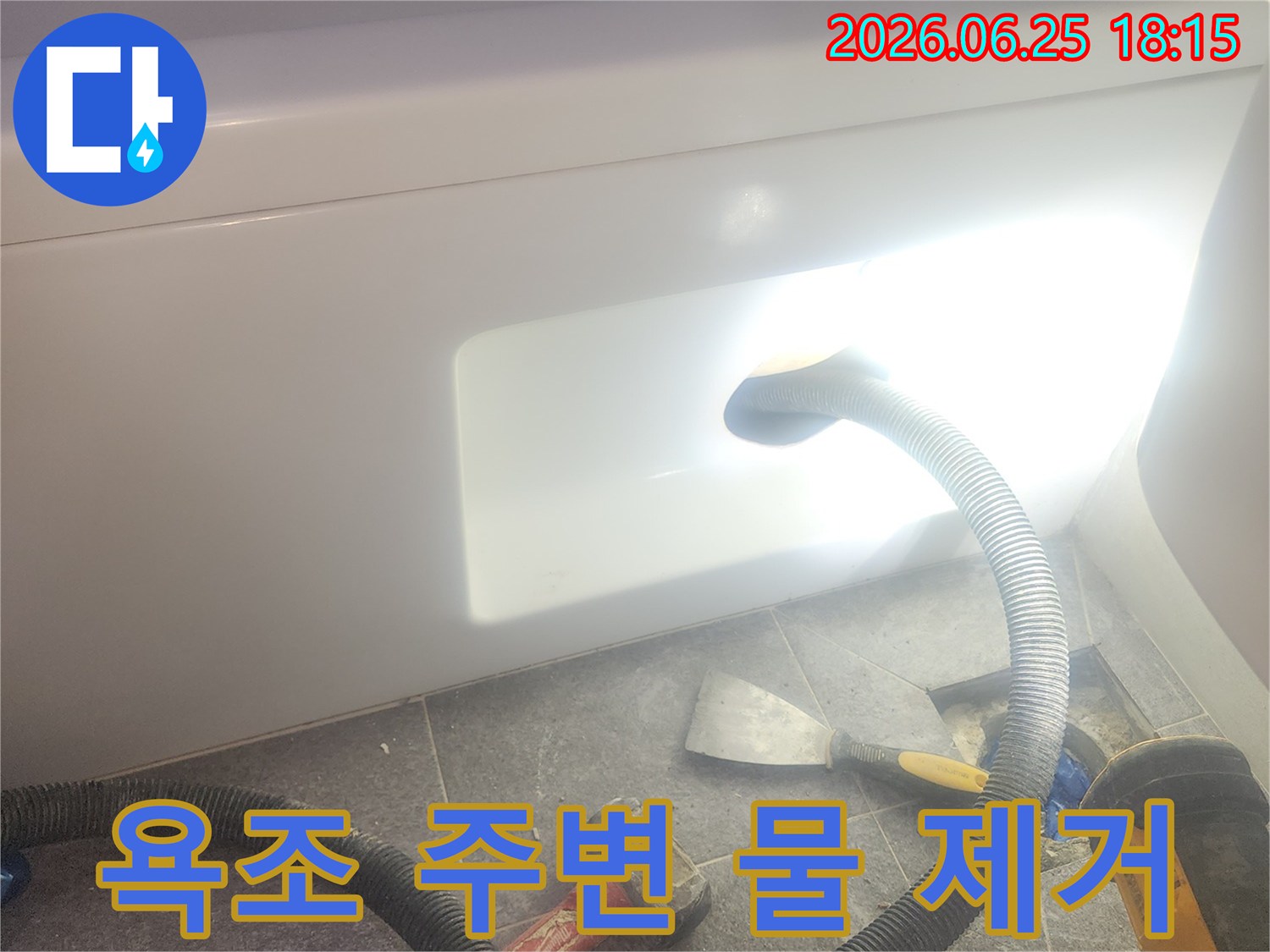욕조 주변에-고인 물을-전문 석션 장비로-흡입하여-제거하는-누수 작업 현장입니다.