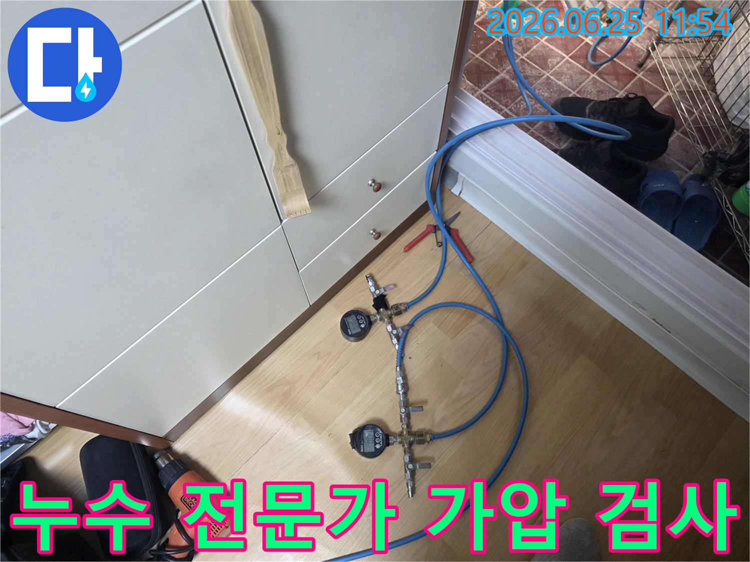 누수 엔지니어가 배관의 압력을 세밀하게 모니터링하기 위해 디지털 압력 게이지가 연결된 가압 테스트 장치를 사용하고 있습니다