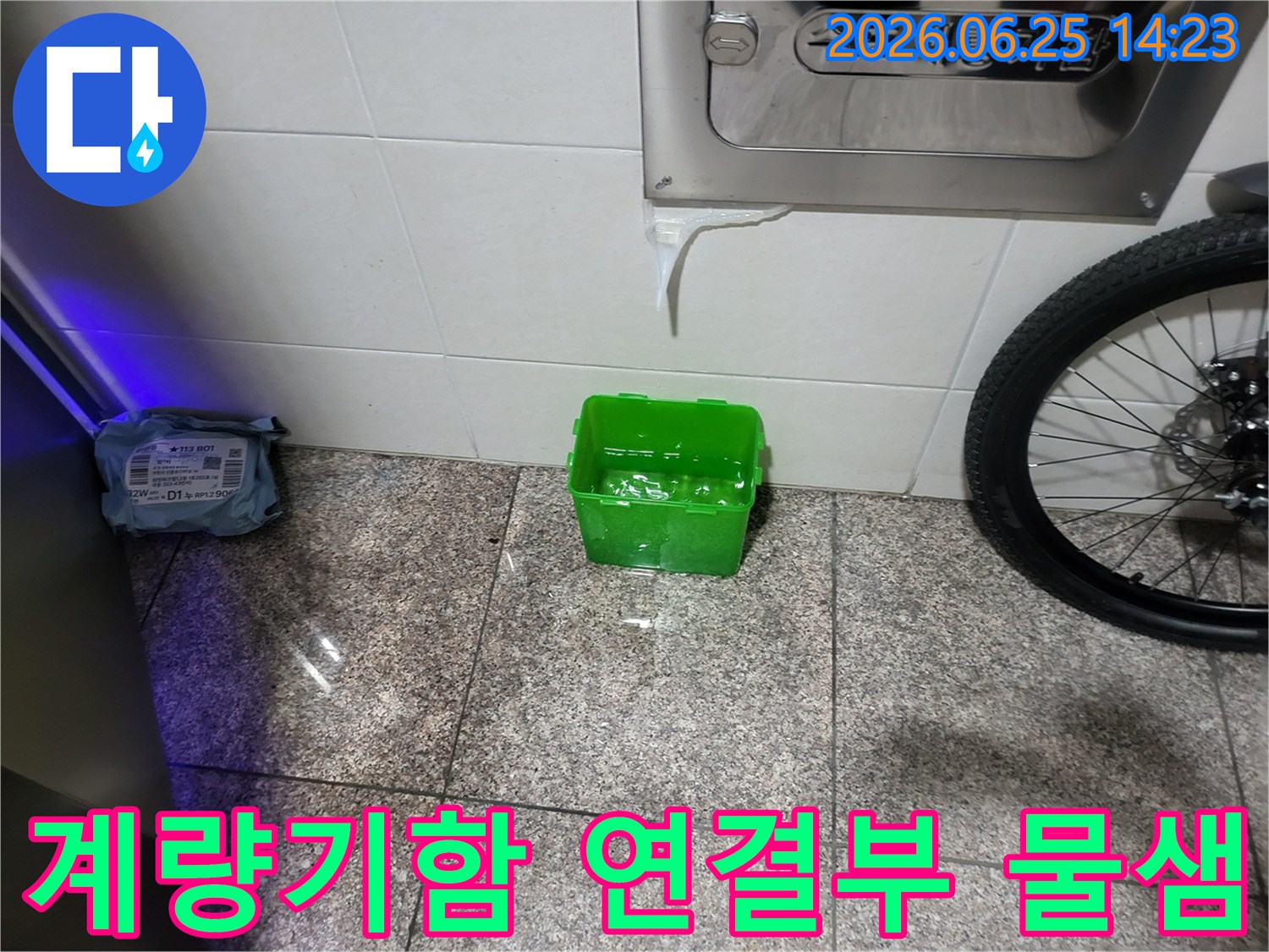 수도계량기함-아래에서-물이-새어-나와-초록색-물받이에-고이는-상황을-보여주는-누수-현장-사진