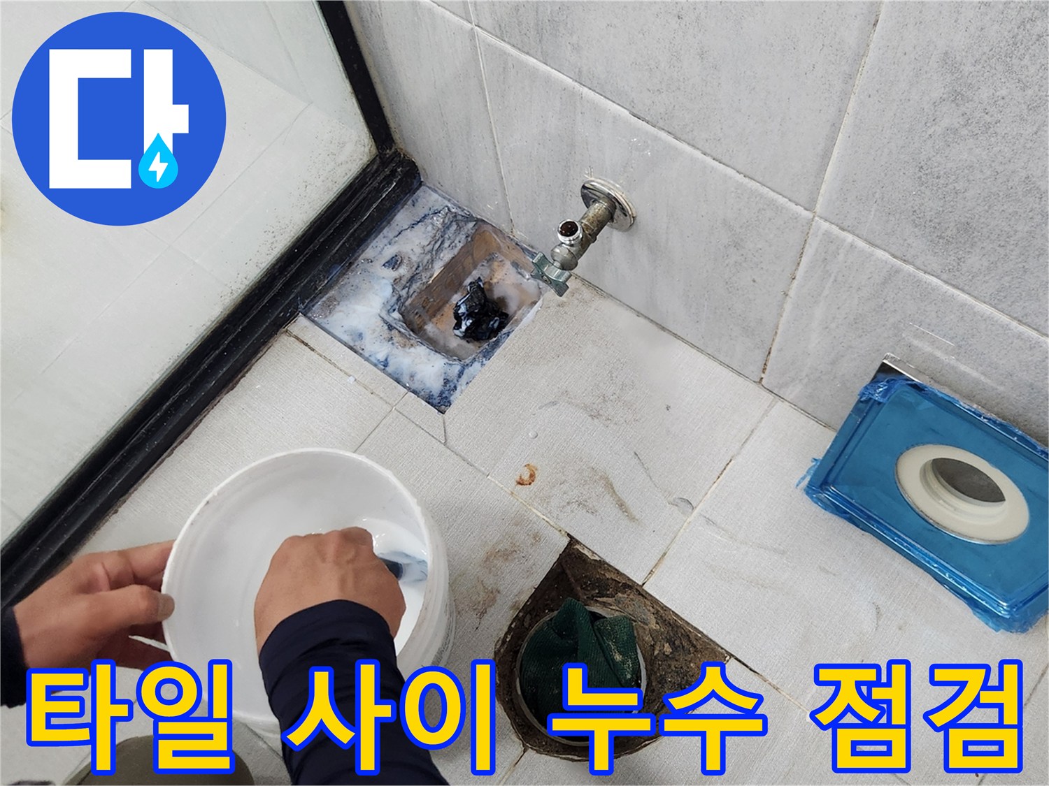바닥 타일과 배수구 접합부의 틈새를 정밀하게 관찰하고 있습니다.