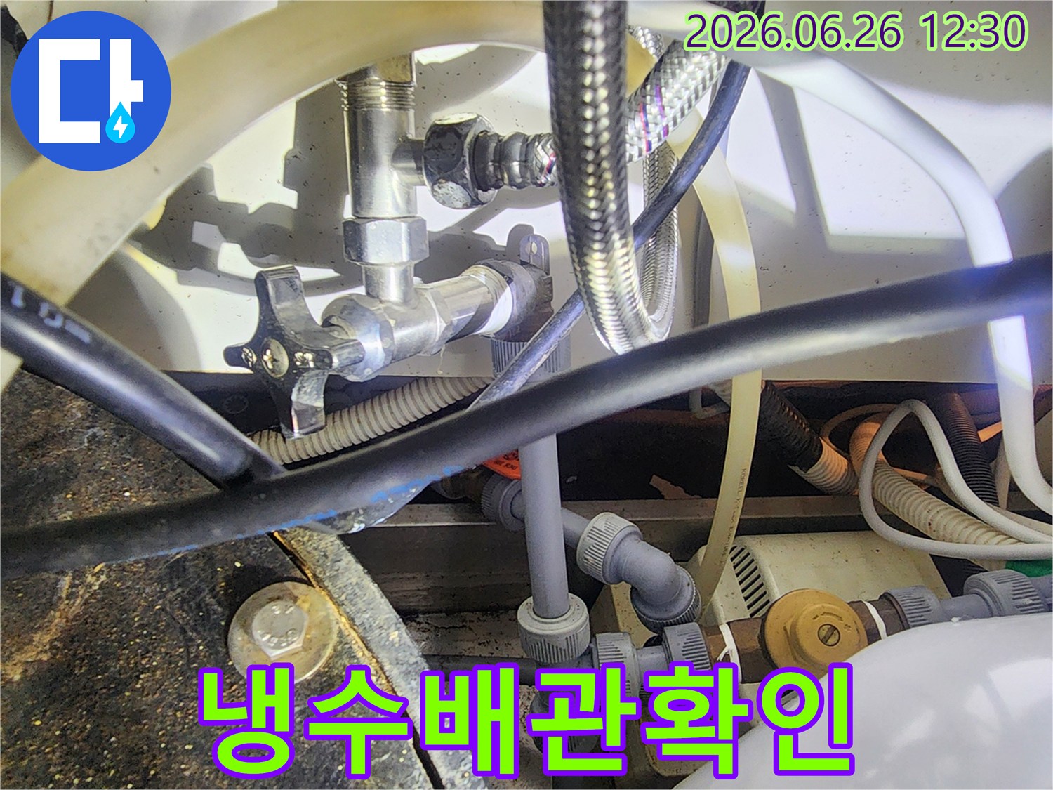 이-사진은-누수-전문가가-배관-연결부위의-상태를-정밀하게-점검하는-모습을-담고-있습니다