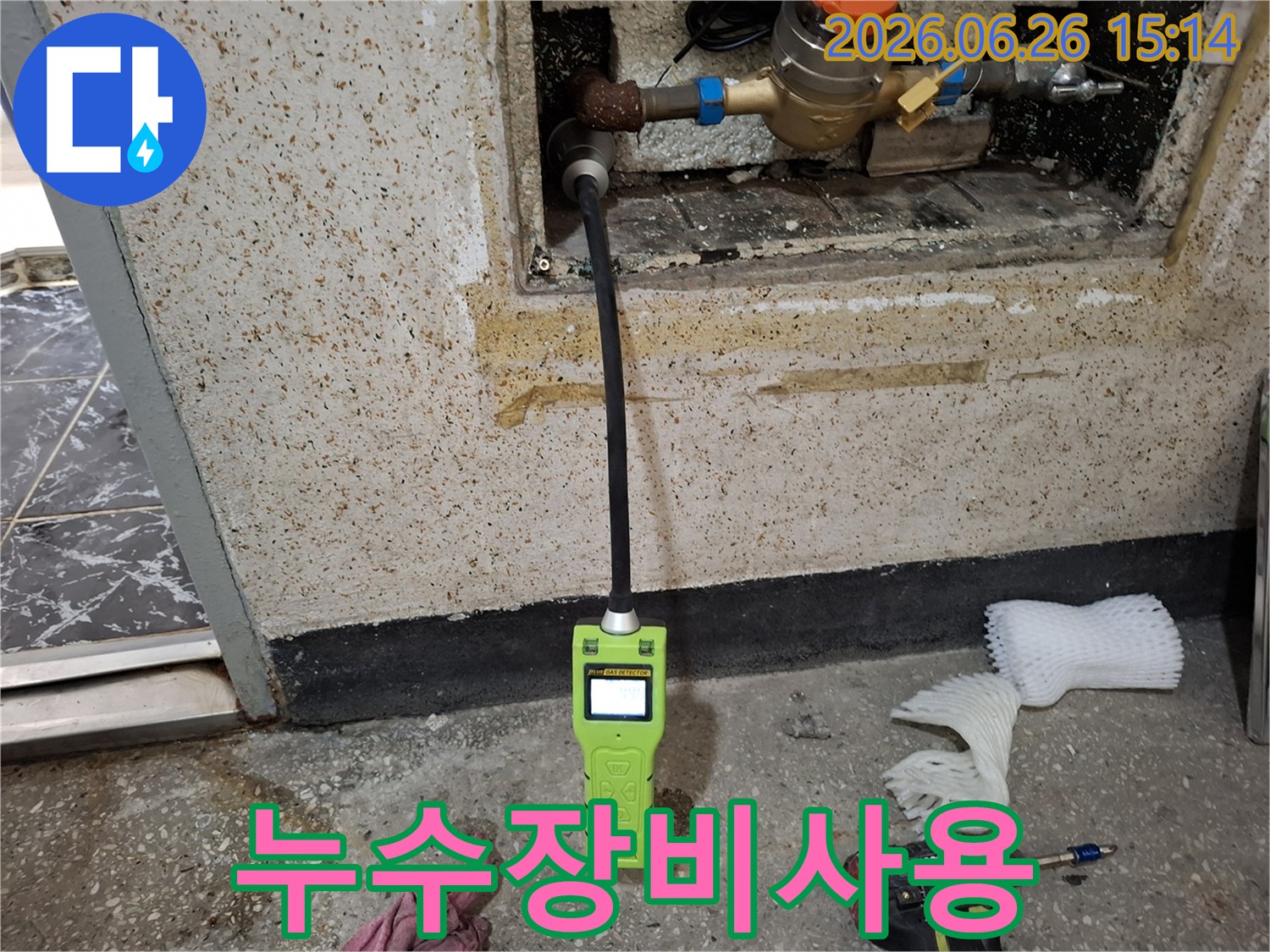 숨겨진 배관 누수를 정확히 찾아내기 위해 첨단 가스 탐지기로 탐지 작업을 진행하는 장면