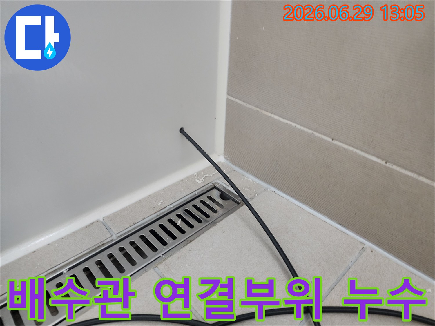 욕실-배수구-아래-배수관-연결부위의-누수-여부를-정밀하게-점검하는-장면