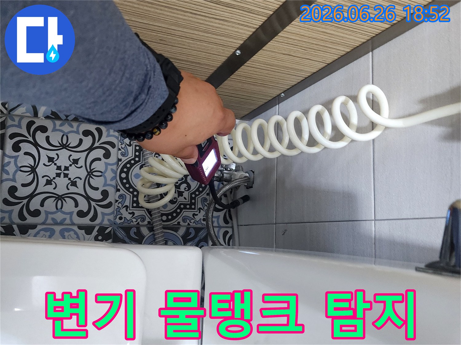 숙련된 엔지니어가 욕실 변기 물탱크 주변에서 누수 탐지 장비로 물샘을 진단하고 있습니다.