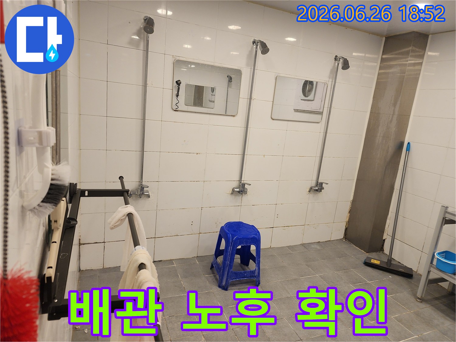 오래된 샤워실의-수도 배관과-샤워 헤드-그리고-벽면 타일의-모습-배관 노후도를-확인하고-있습니다