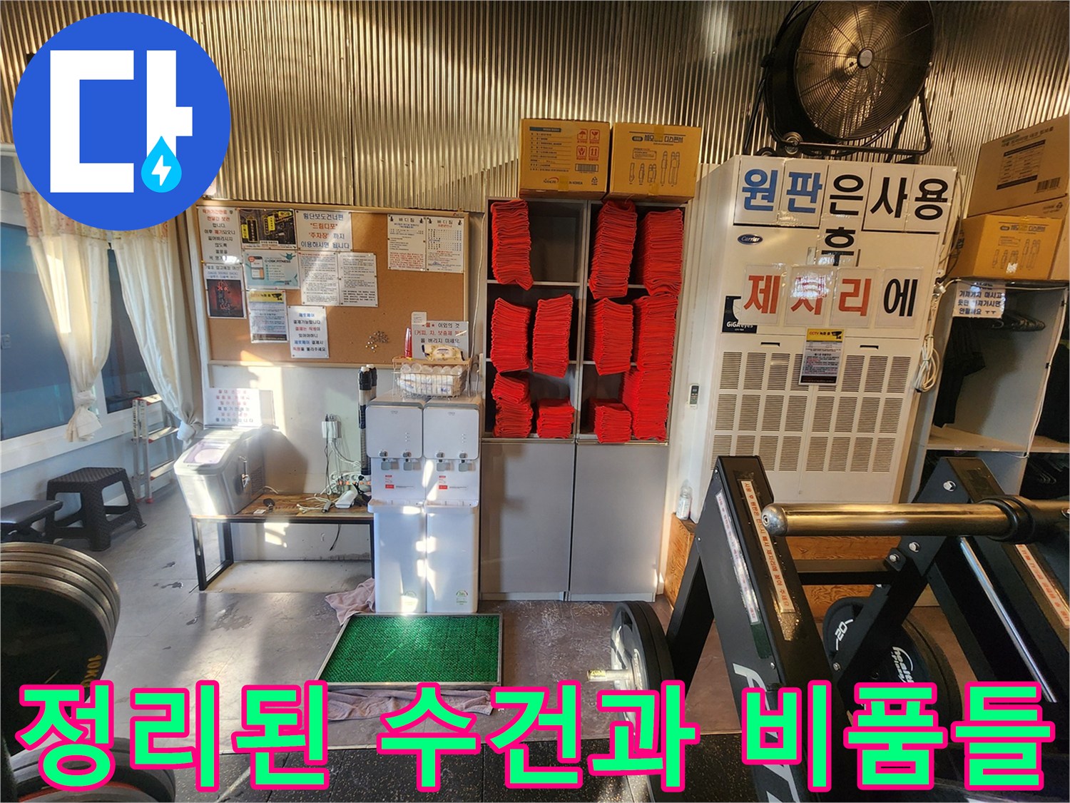 헬스장 수납 공간에 정리되어 있는 빨간색 수건들과 상자들