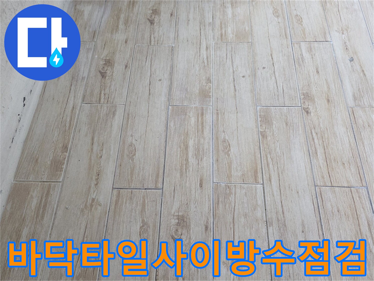 세탁실 바닥 타일과 배수관 연결 부위의 마감 상태를 세밀하게 관찰하는 장면