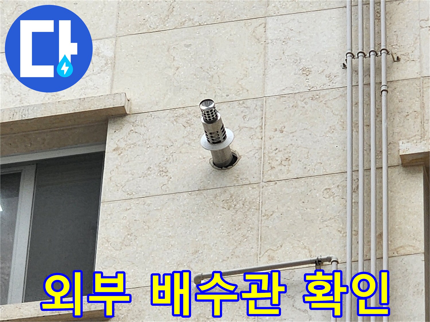 스테인리스 소재의 외벽 돌출 배수관과 석재 마감면 상세 촬영