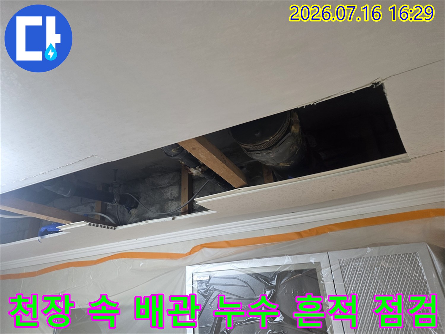 천장 내부에 설치된 배관을 육안으로 검사하며 문제 부위를 찾는 모습