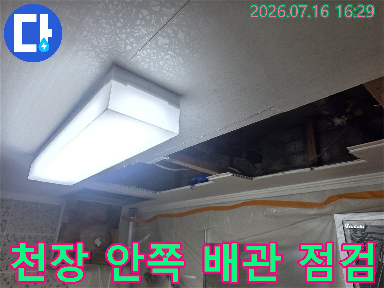 천장 조명과 인접한 화장실 내 배관 점검 상황