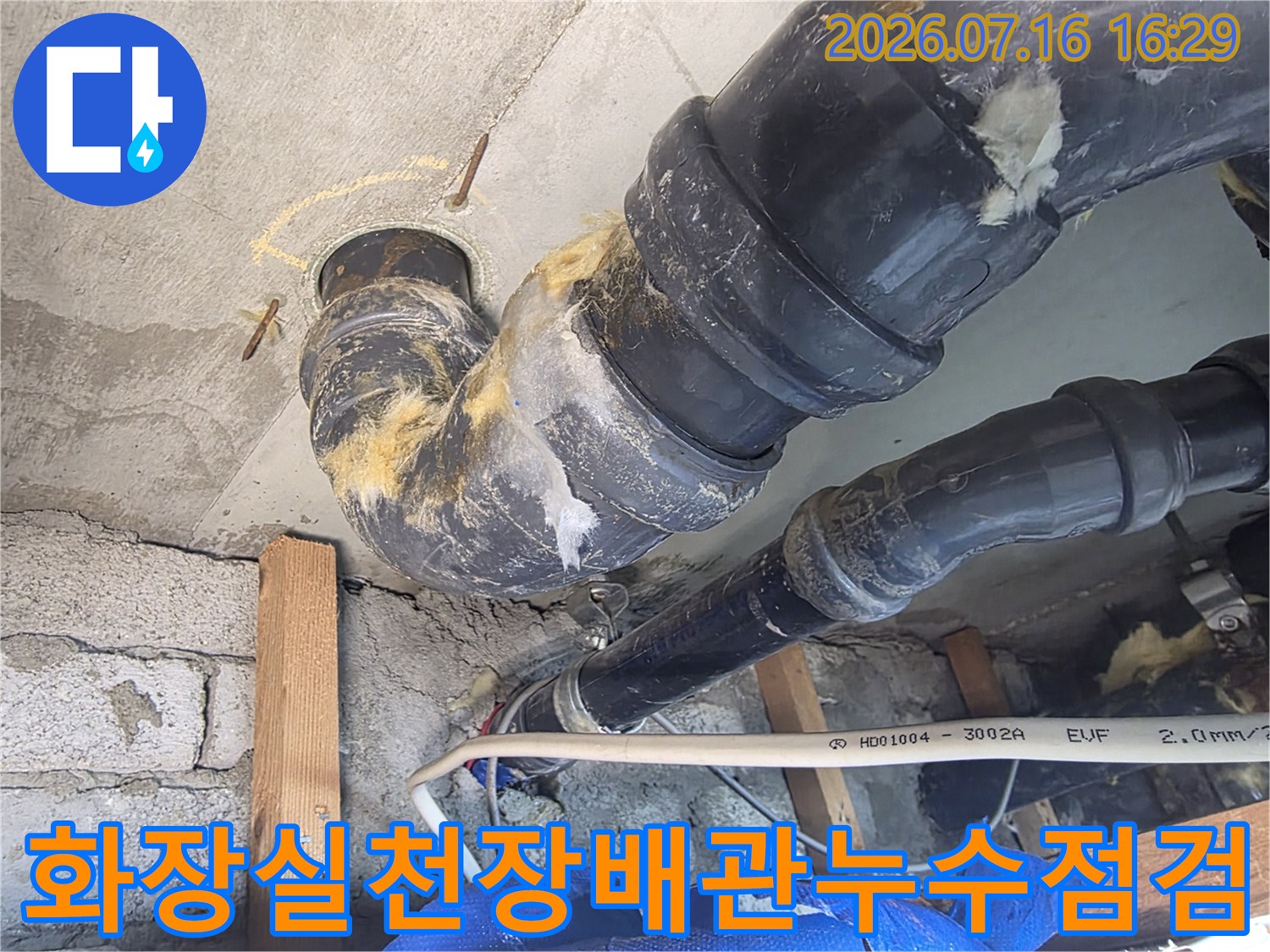화장실 천장 내부의 노출된 배관과 누수 흔적이 있는 연결 부위 점검 모습