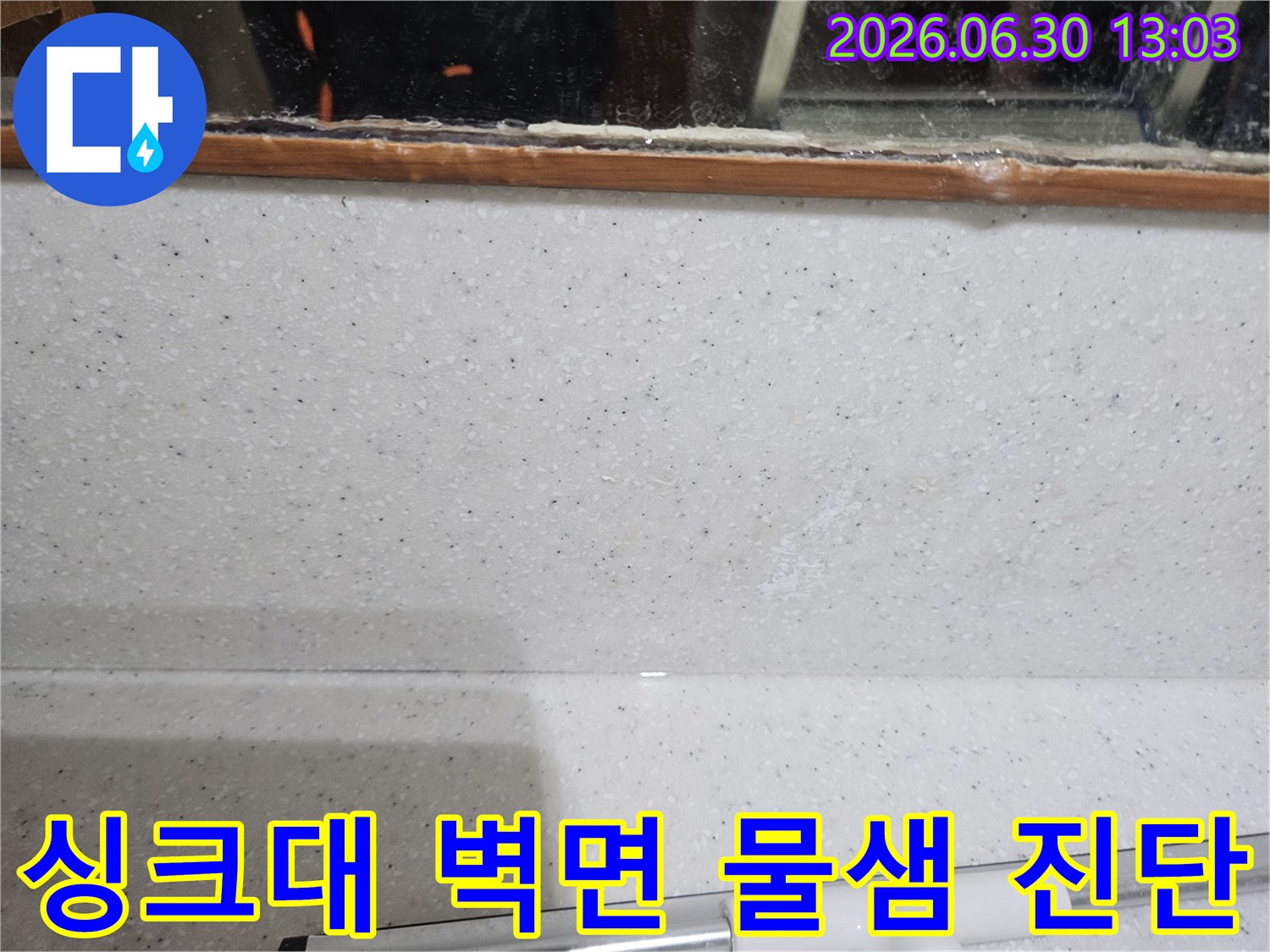 주방 싱크대-벽면과 상판 경계에서-발견된-희미한 물자국을-전문가가 세밀하게 관찰하며-진단하는 모습