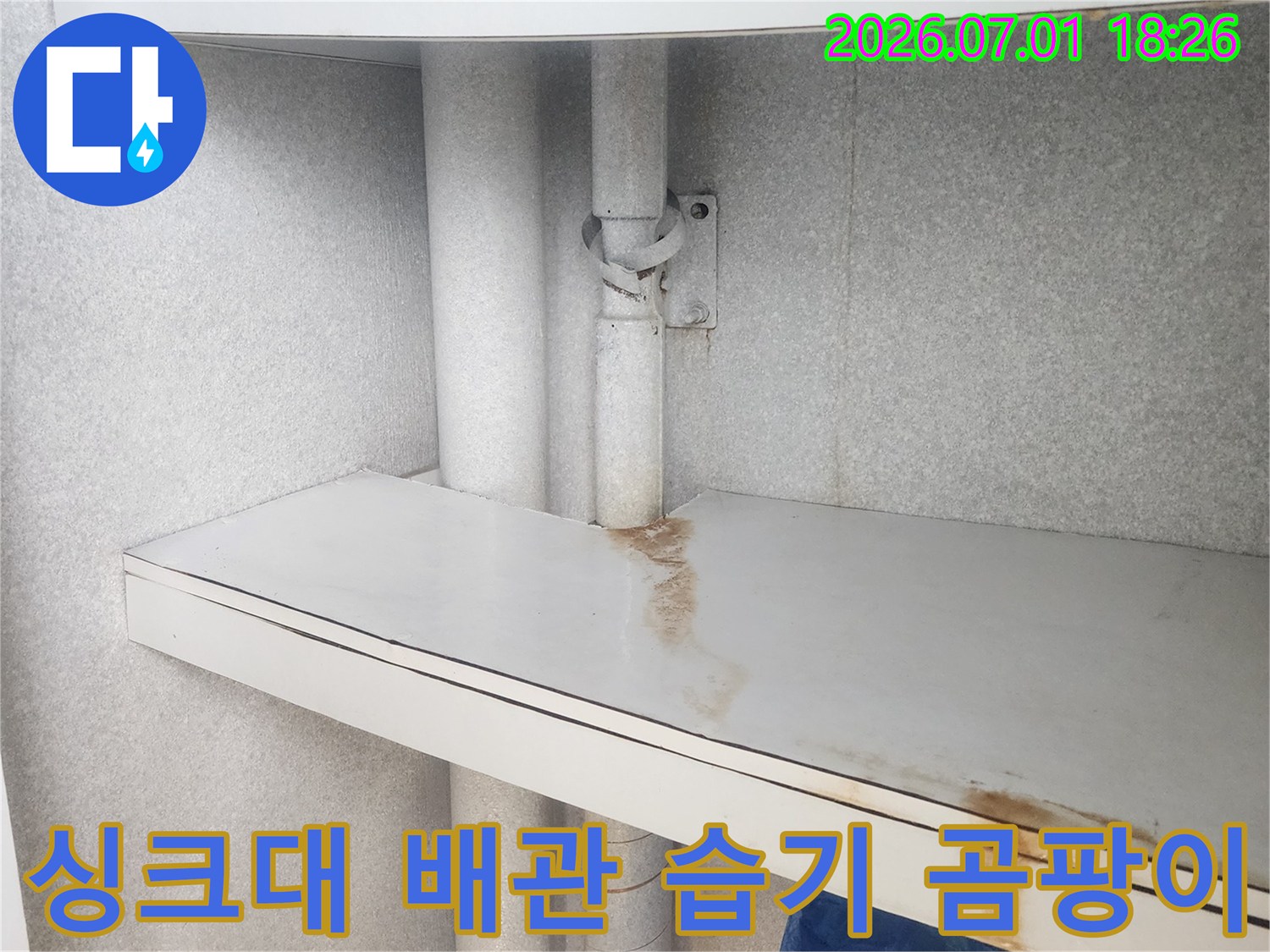 이 사진은-싱크대 하부-배관 주변에-지속적인 누수로 인해-발생한-습기 흔적과-곰팡이 발생 가능성을-보여줍니다