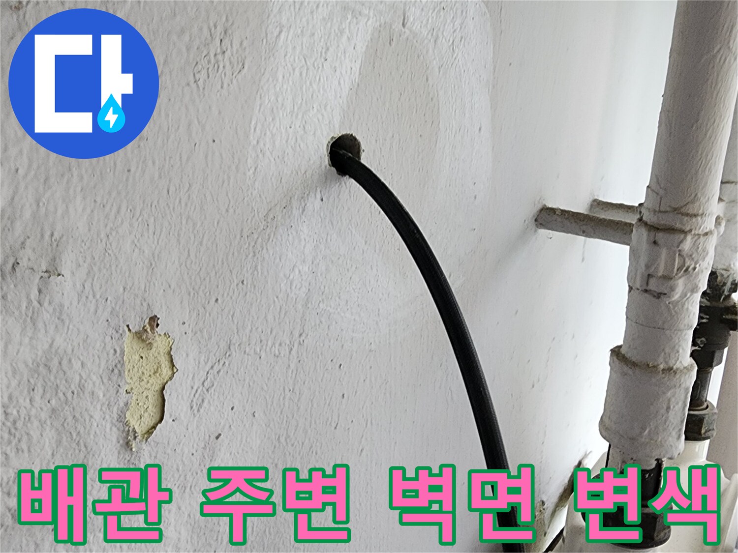 배관 하단 벽면에 나타난 누수로 인한 어두운 얼룩과 오염