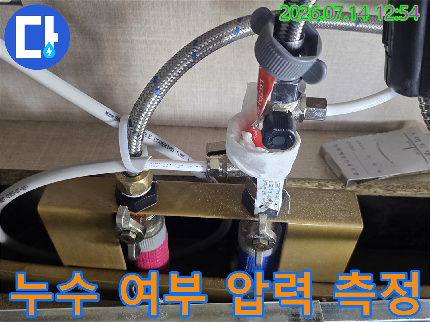 싱크대 하부 배관에 게이지를 연결하여 기밀성을 테스트하는 기술적 과정