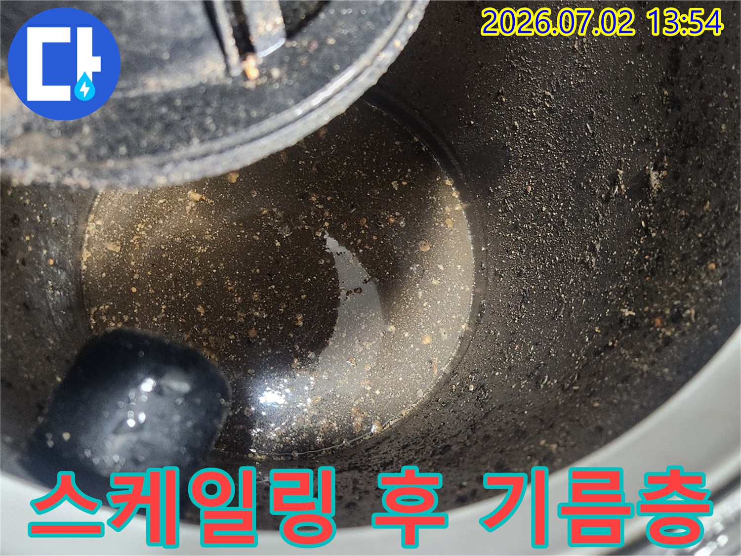 배관 스케일링 1차 작업 완료 후-석션 장비 내부에 포집된-굳은 기름층과 오염물질을 보여주는 클로즈업 사진