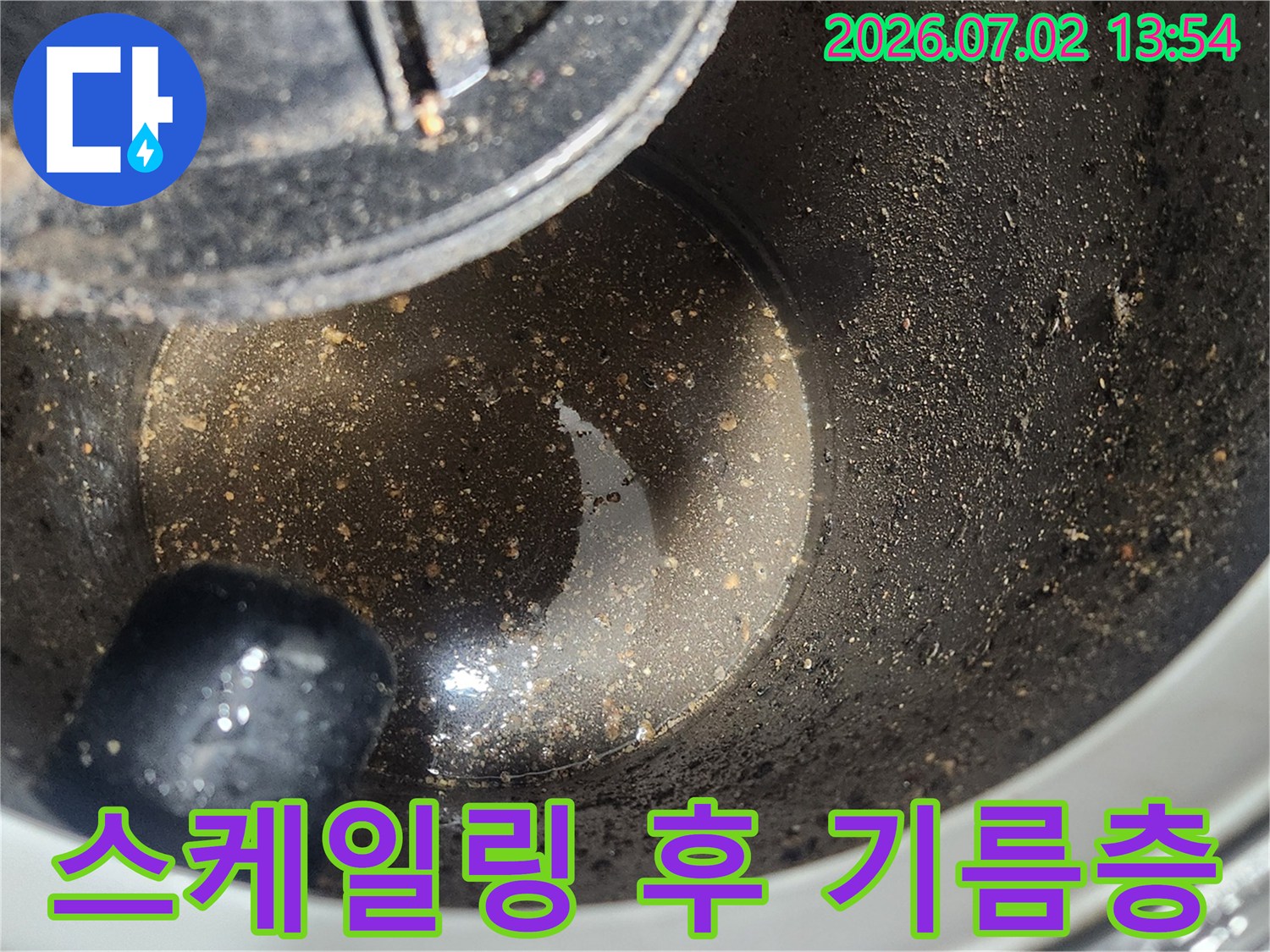 배관 스케일링 1차 작업 완료 후-석션 장비 내부에 포집된-굳은 기름층과 오염물질을 보여주는 클로즈업 사진