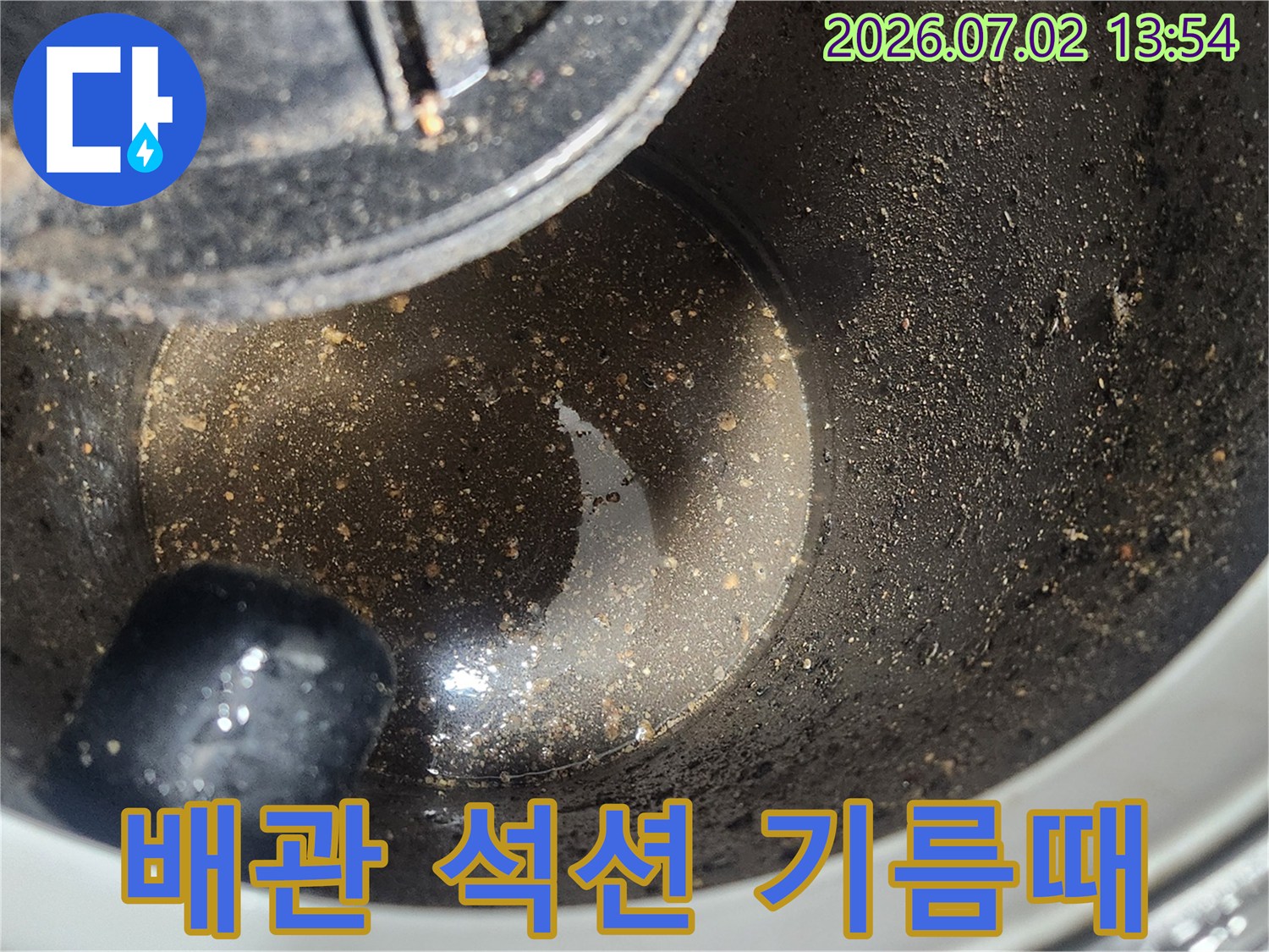배관 스케일링 1차 작업 후-석션 장비로 제거된-굳은 기름때와 슬러지 상태를 보여주는 사진