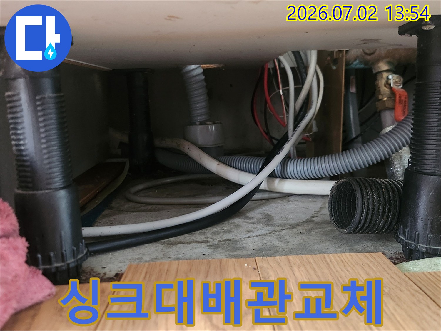 싱크대-하부-공간에서-오래된-배수-호스를-제거하고-새로운-호스로-교체하는-작업-과정을-보여줍니다.