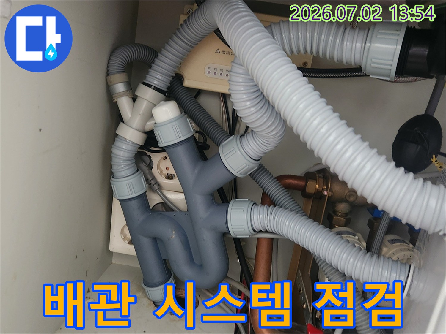 이 사진은-싱크대 하부의-복잡한 배관 시스템을-전체적으로 점검하는-모습을 보여주며-누수 예방을 위한-종합적인 접근의-중요성을 강조합니다.