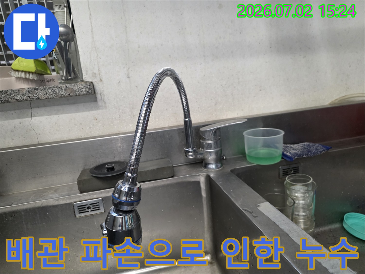 노후된 수전과 부식된 금속망 배관이 연결된 주방 싱크대 하단 설비 사진