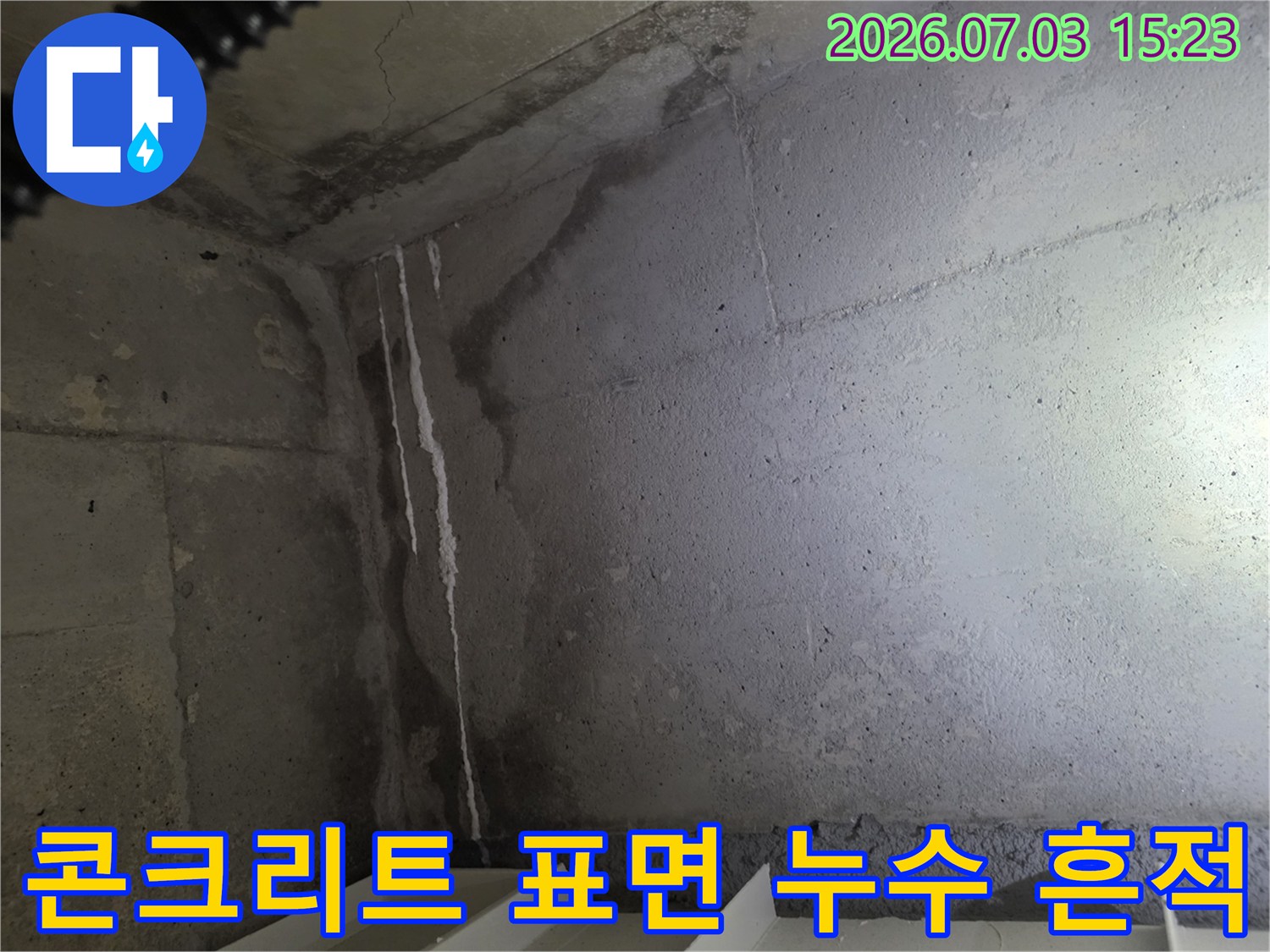 화장실 천장의 콘크리트 벽면에 하얗게 굳은 석회가 수직으로 길게 늘어진 모습