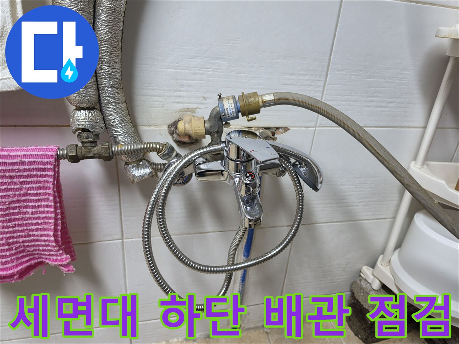 화장실 세면대 아래쪽 수도 호스와 벽체 배관 연결 부위 근접 촬영