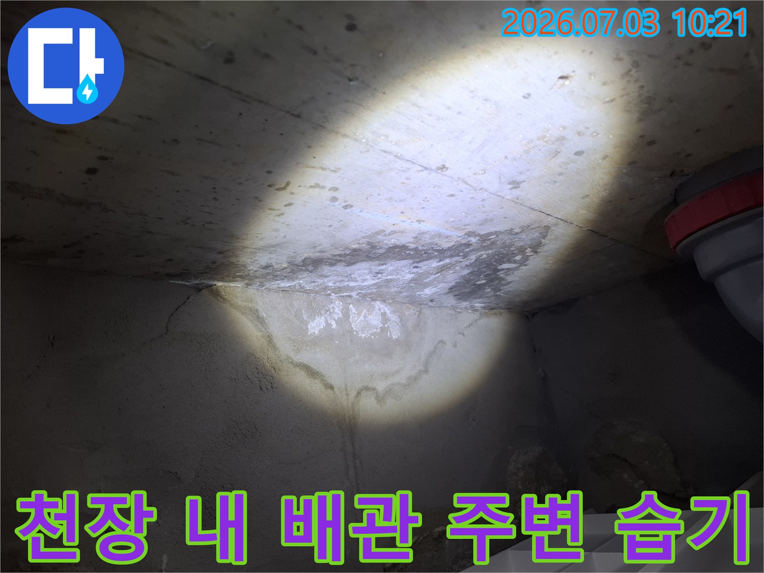 강력한 랜턴으로 비춘 천장 내부의 젖은 부위와 배관라인을 촬영한 사진