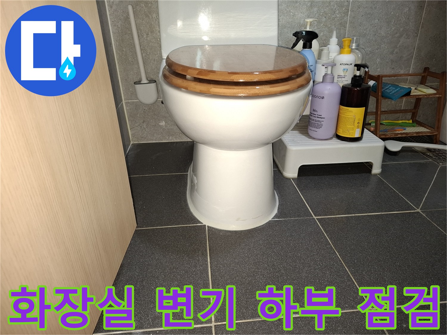변기 주변 타일과 세정 용품이 놓인 모습