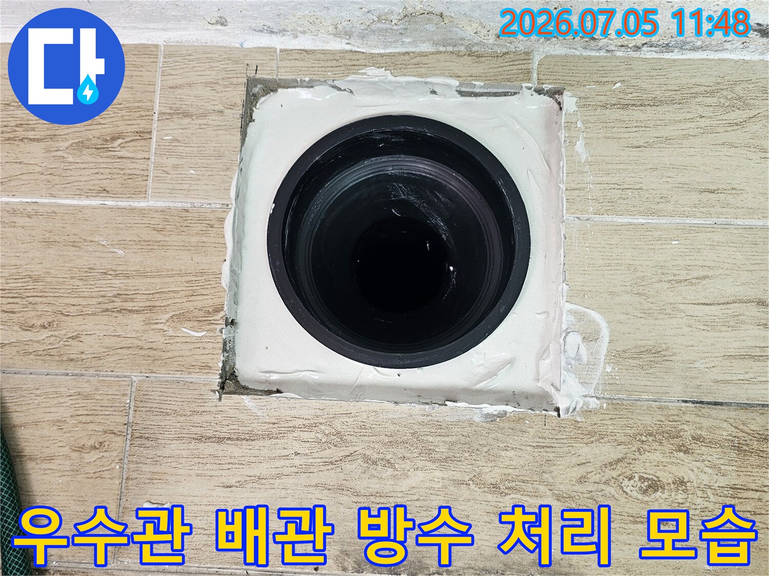 우수관 주변에 하얀색 방수제로 마감 처리된 배관 입구의 상세 사진