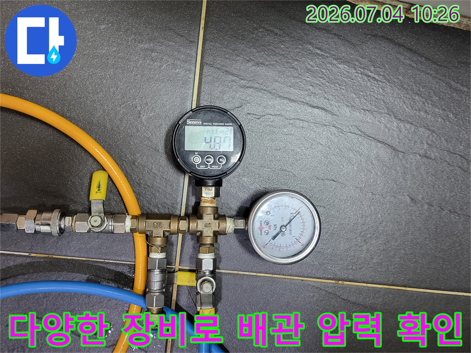 멀티 컬러 호스와 두 가지 타입의 게이지가 연결된 누수 점검 현장