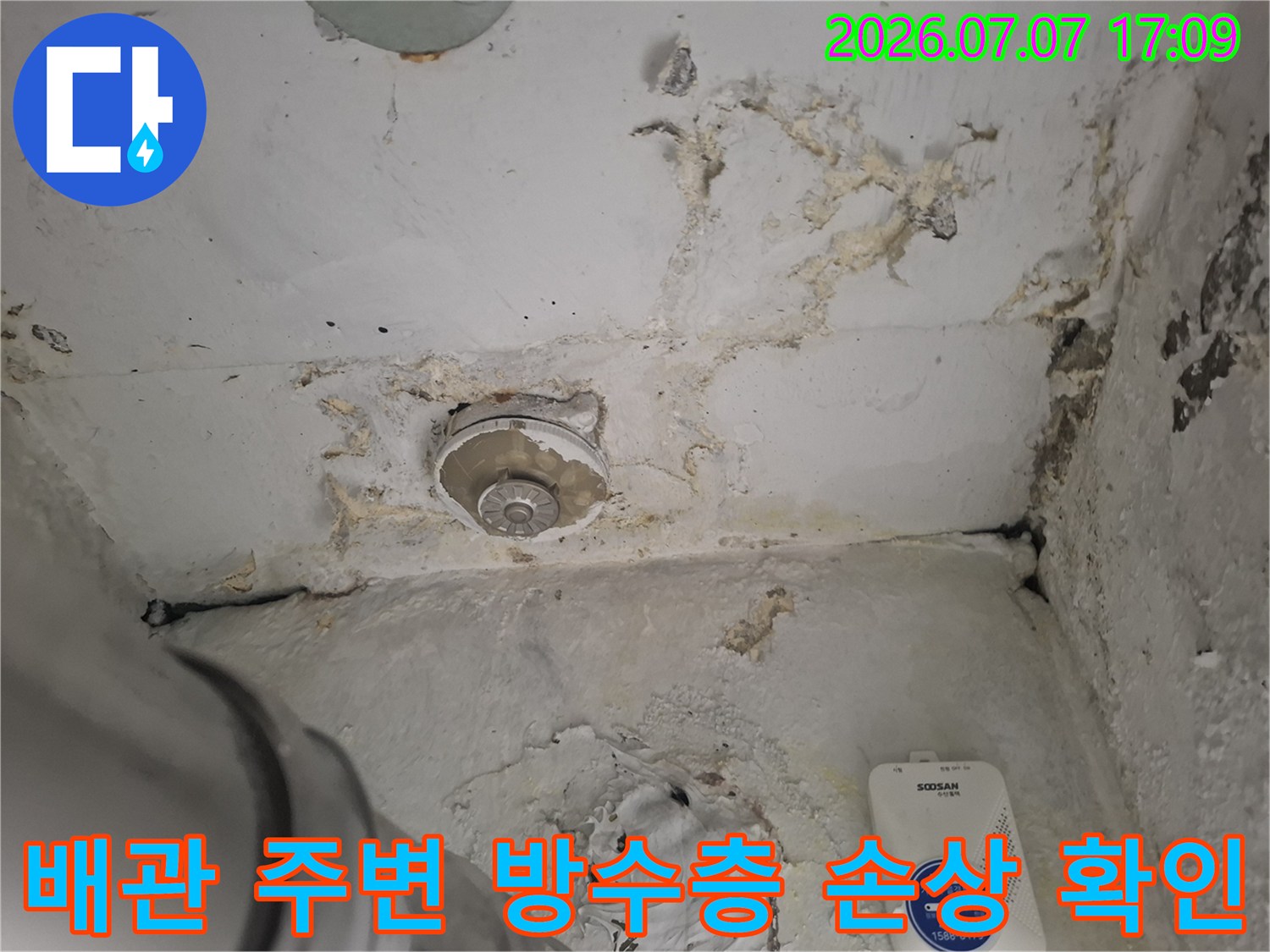 손상된 우수관 주변의 노후된 방수층과 오염 부위를 촬영한 사진