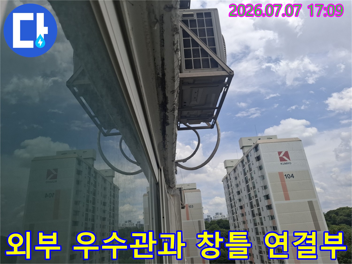 우수관과 아파트 외벽 창틀이 연결된 구조물 사진