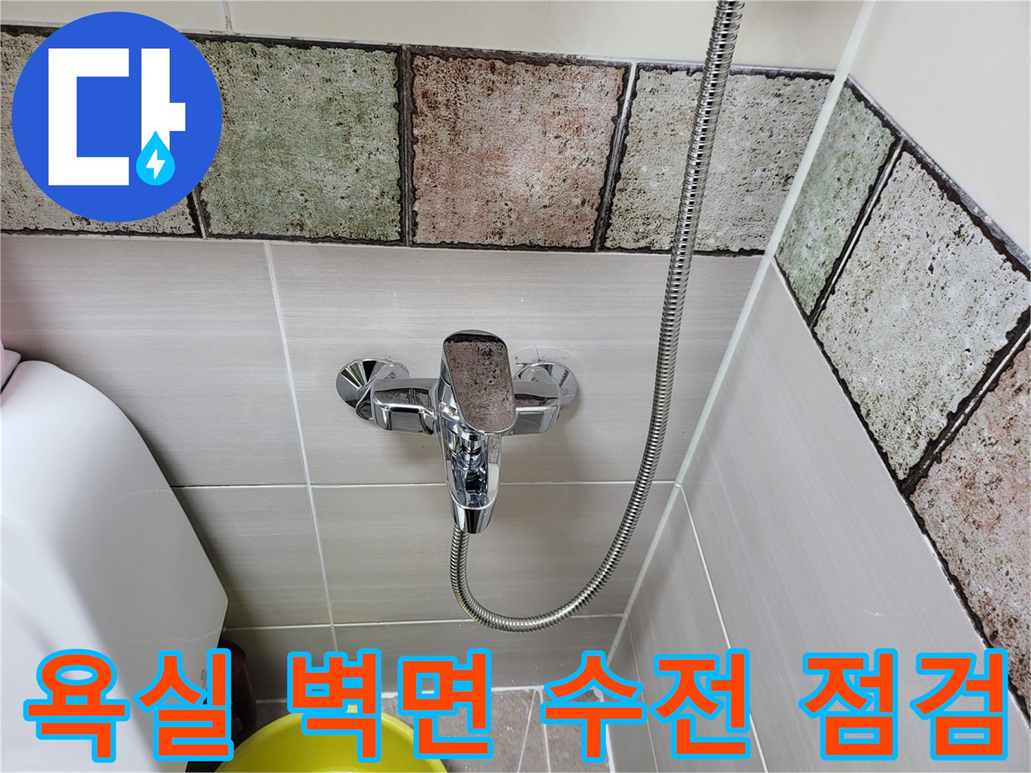금속 재질의 샤워 수전과 타일 마감 상태입니다.