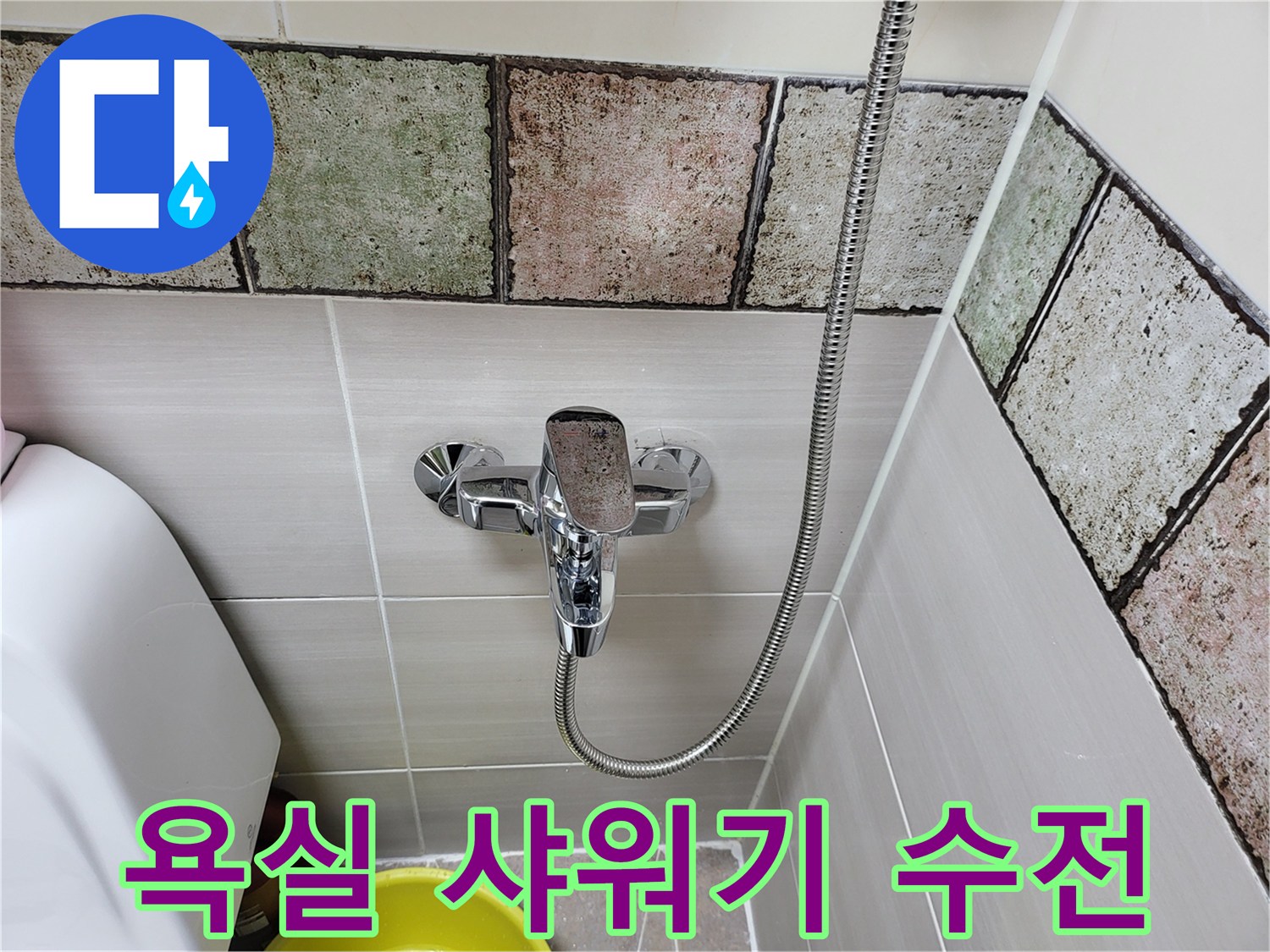 욕실 벽면에 설치된 크롬 도금 샤워기 수전의 모습입니다.