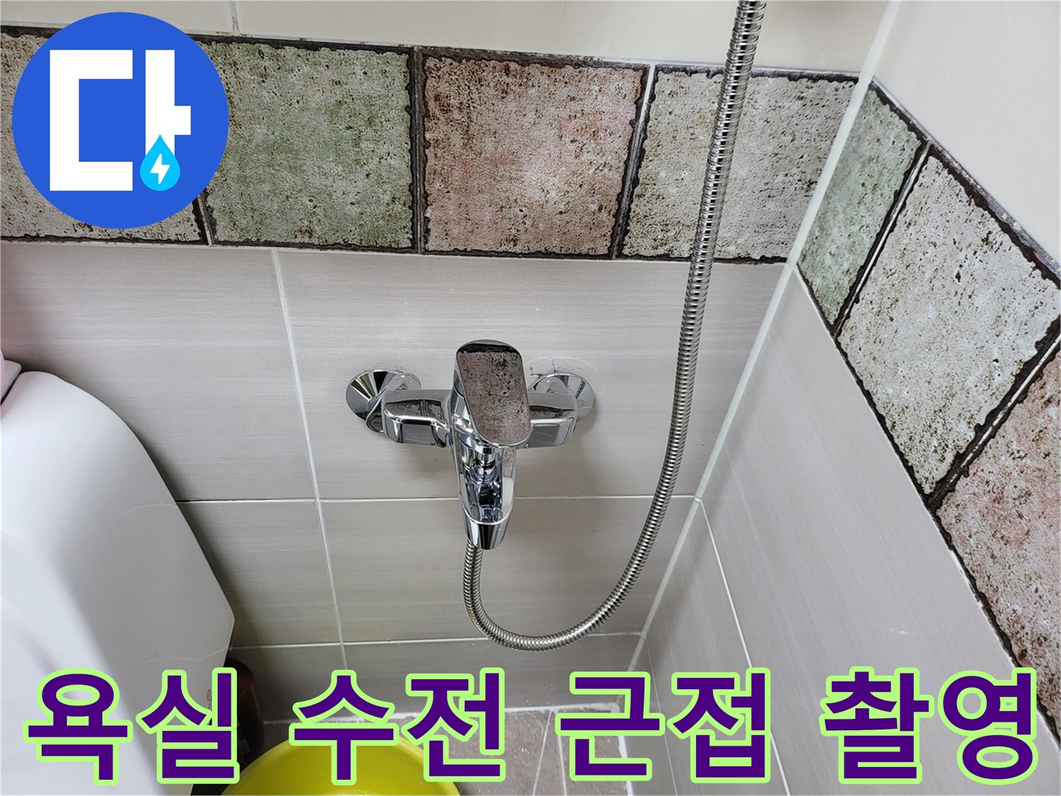 타일 벽면에 부착된 샤워기 수전과 연결 호스