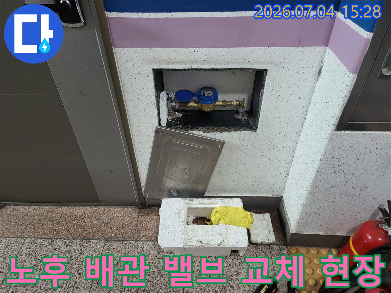 파란색 보호 캡이 씌워진 수도 밸브와 계량기함 내 노출 배관 수리