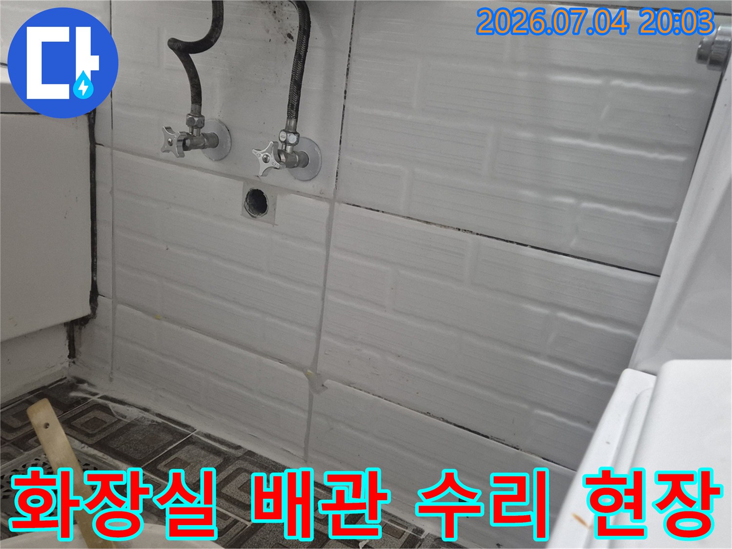 화장실 벽면에 노출된 수도 배관과 밸브 연결부위의 점검 모습