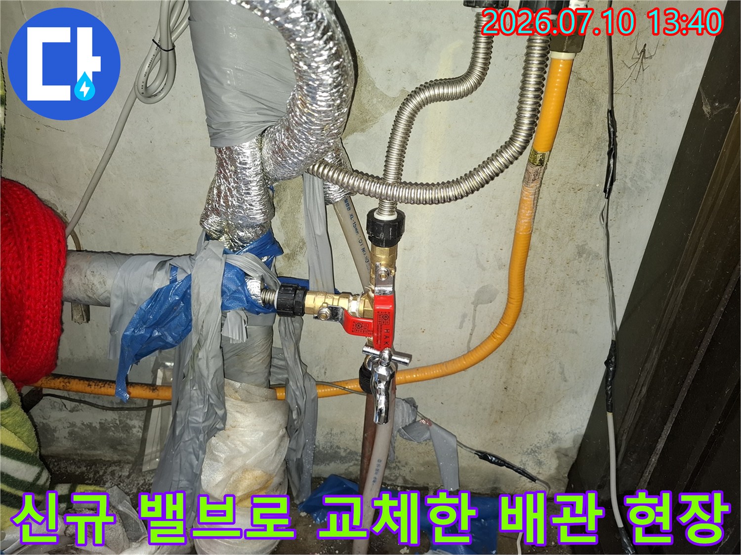노후된 금속 재질의 배관과 새롭게 설치한 황색/빨간색 밸브 연결부