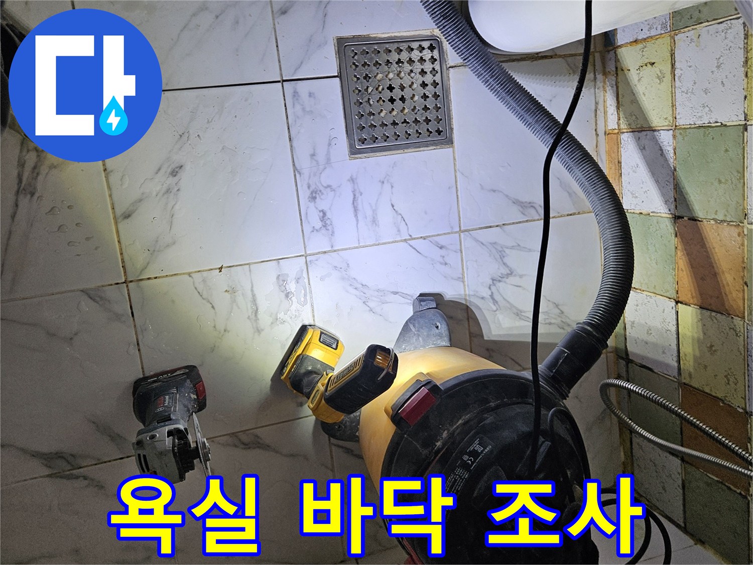 작업용 전동 공구와 청소기가 배치된 화장실 내부