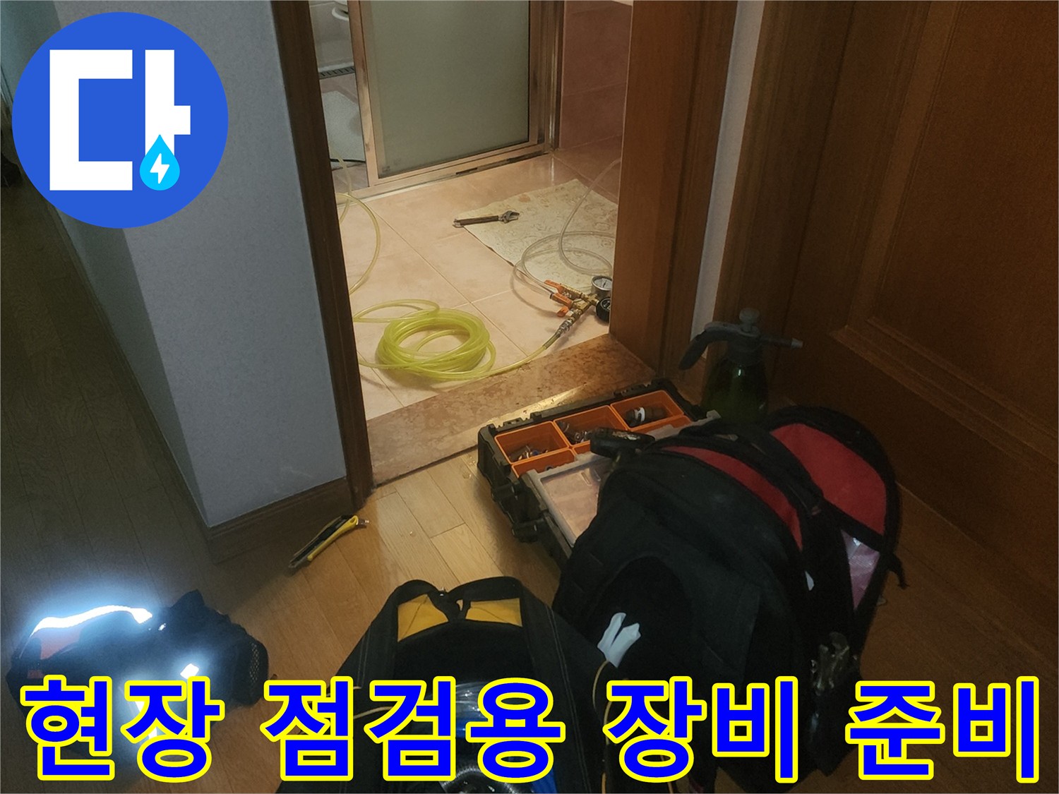 욕실 바닥에 배치된 누수 탐지용 호스와 압력계 연결 장치