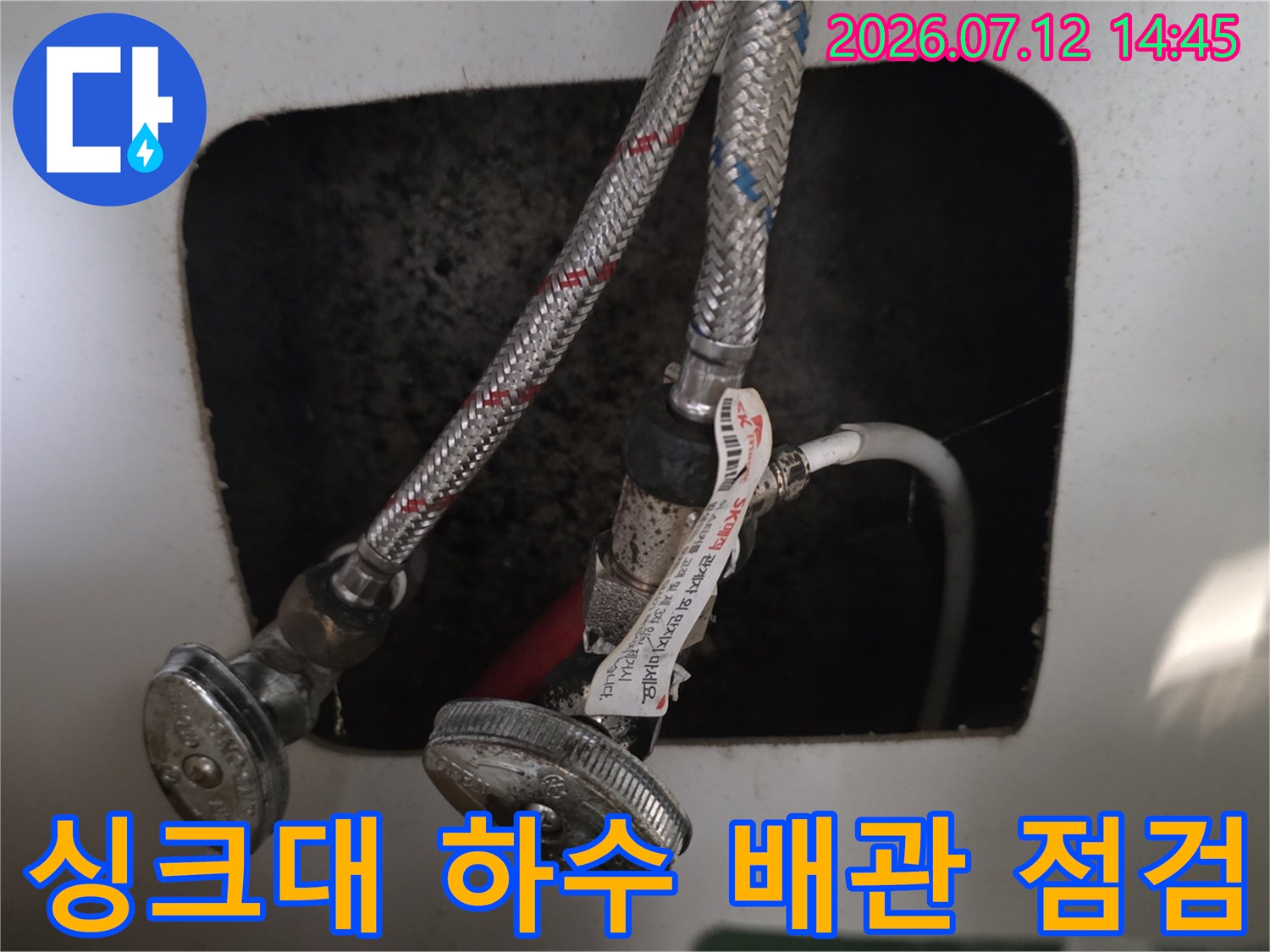 싱크대 아래 설치된 노출 배관과 연결 부위를 점검하는 모습
