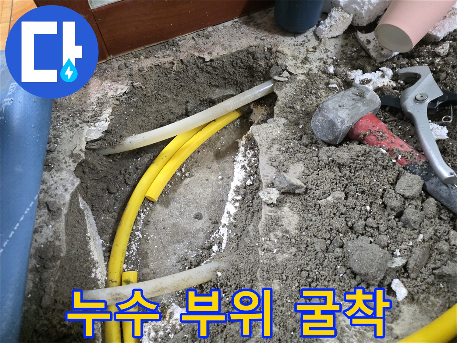 흙을 파내어 드러난 노란색 배관과 공구들