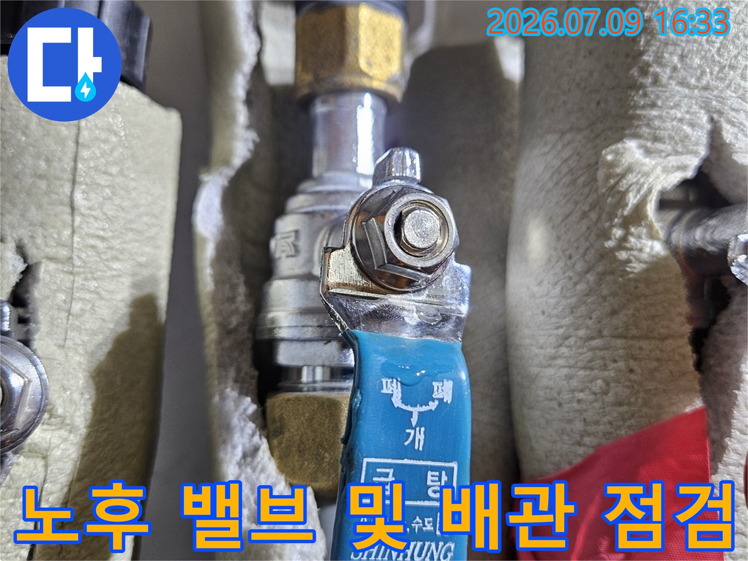 금속 재질의 노란색 부품과 파란색 밸브가 결합된 온수 배관라인
