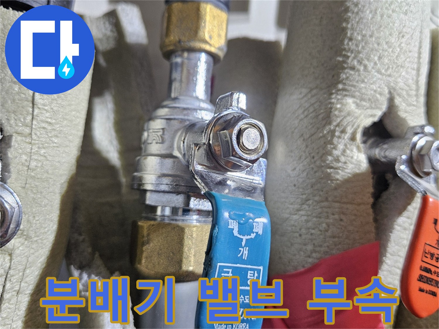 금속 재질의 분배기 밸브와 단열재로 마감된 배관 모습